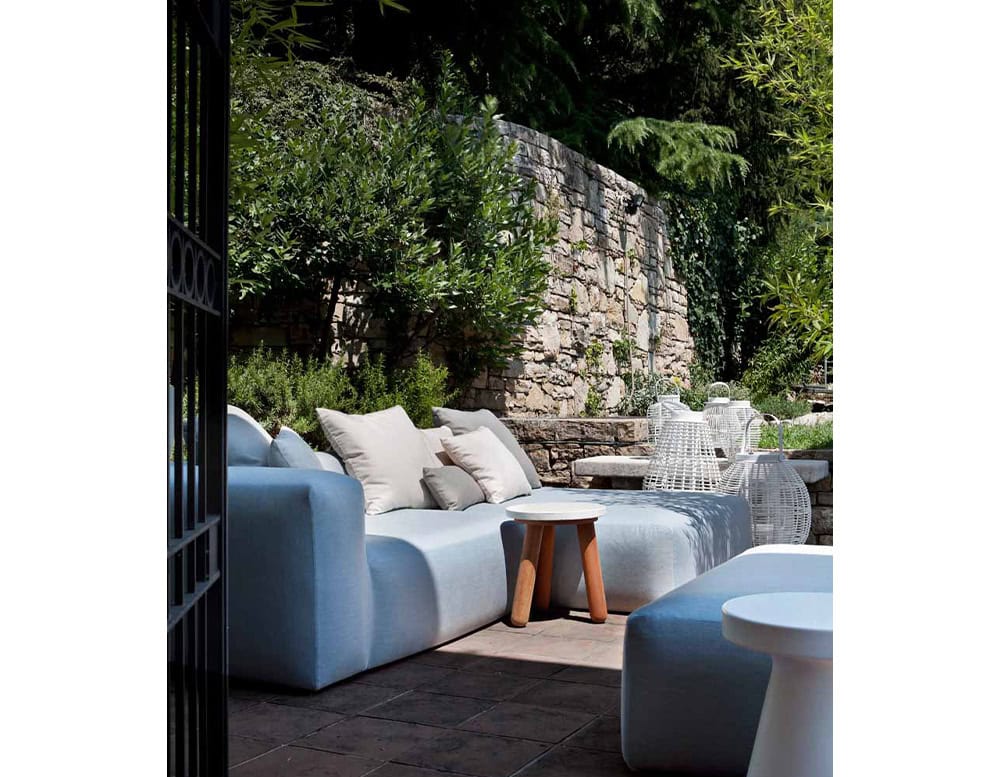 Two Montecarlo Lounge with backrest and armrest in blue fabric with pillows on a terrace.