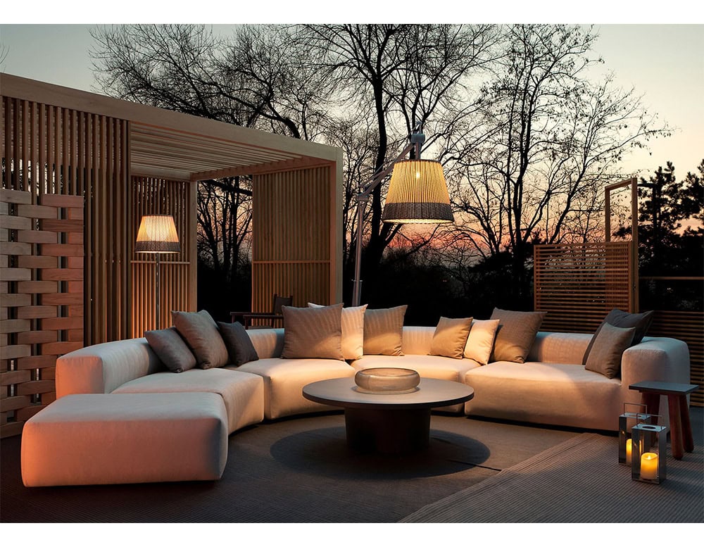 Four Montecarlo Lounges with backrest and armrest in gray fabric with pillows on a terrace.