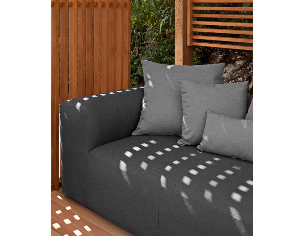 Montecarlo Lounge with backrest and armrest in gray fabric with pillows on a terrace.