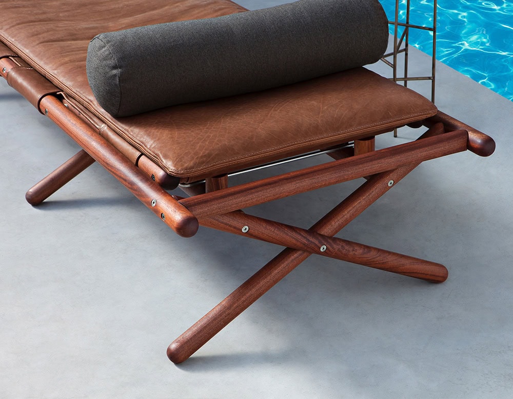 Paraggi Sun Lounger. Structure in brown wood upholstered in brown leather and black cushion on a white background.