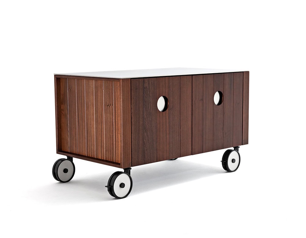 Roller Kitchen cabin covered in brown wooden with four wheels against a wall.