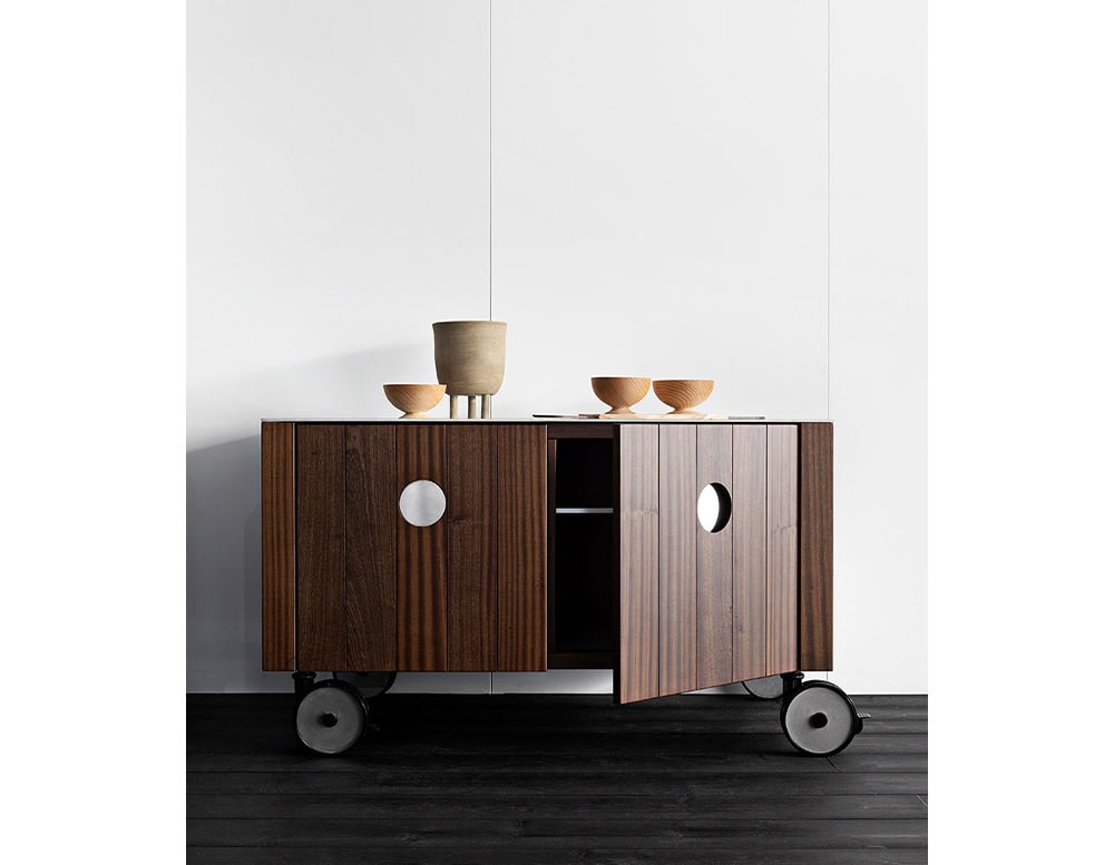 Roller Kitchen cabin covered in brown wooden with four wheels against a wall.