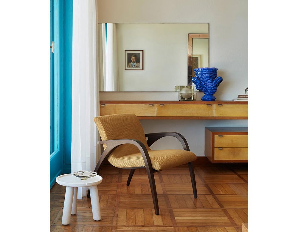 White Stone Round Coffee table in white with three legs in a living room.