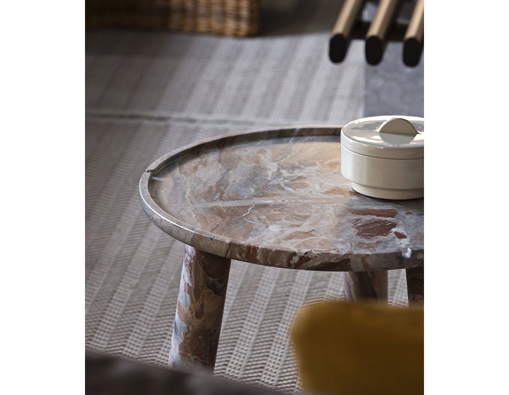 Stone Round Coffee Table in brown and gray stone on a gray floor.