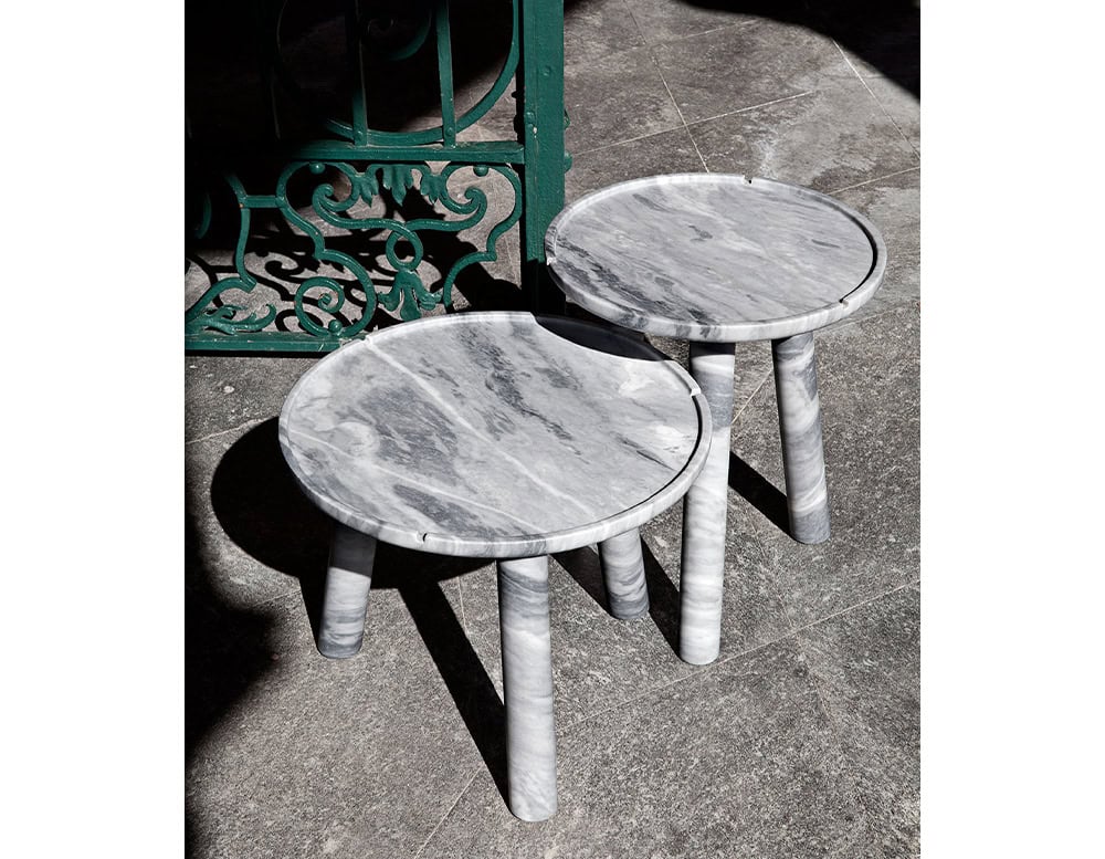 Two Stone Round Coffee Tables in white and gray stone on a gray floor.