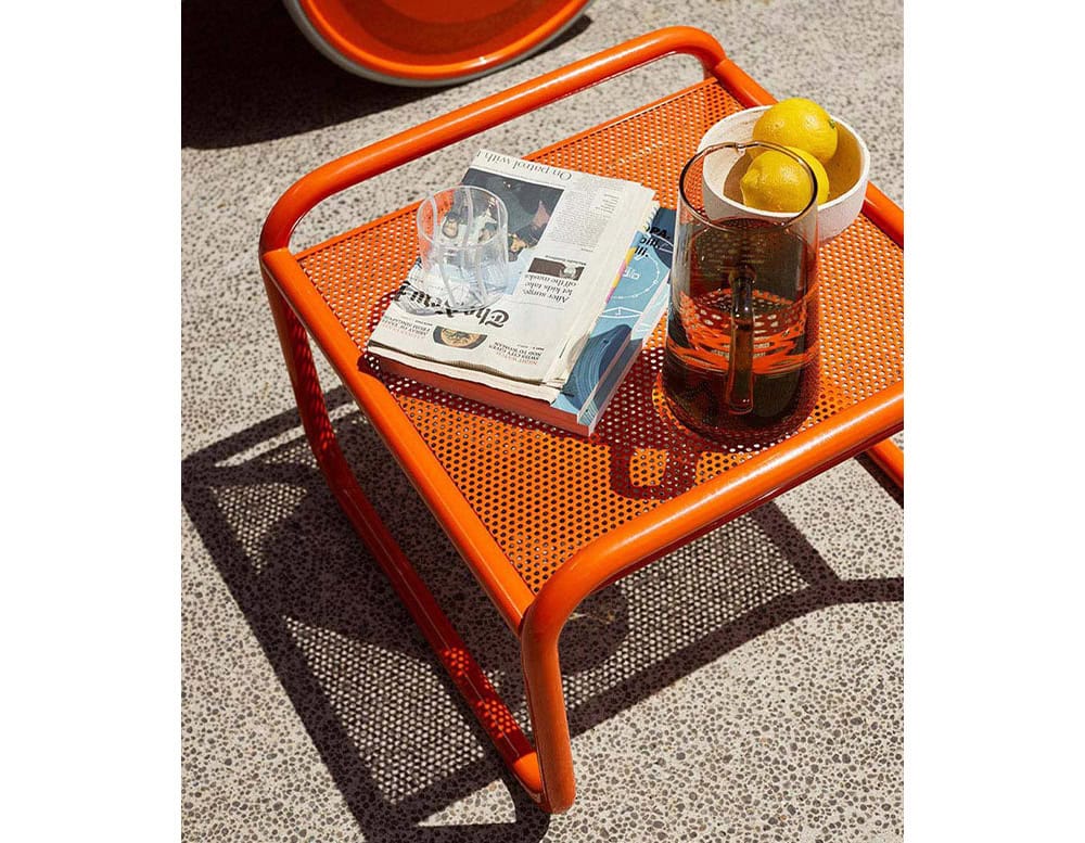 Locus Solus Pouf 1964. Metal structure in orange. Hole top and four legs on the floor.