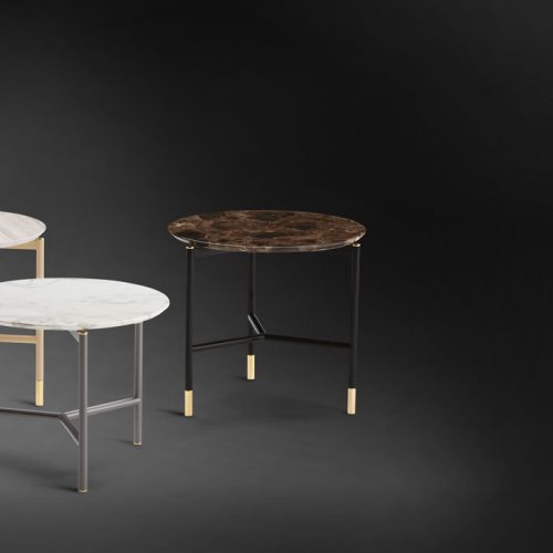 Iko Side Table. Round top in white, gray and brown, legs in gold, silver and black on a black background.