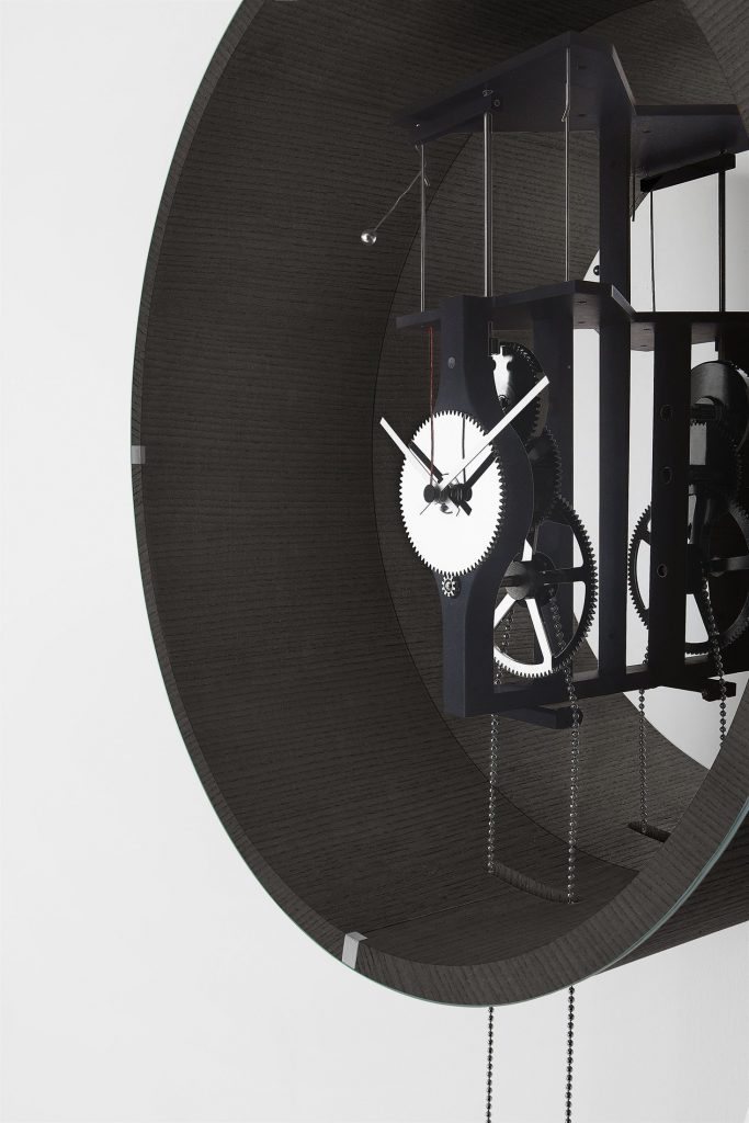 Black Tic Tac 14 pendulum clock with a sleek design, featuring a round face and slender pendulum on a white background.