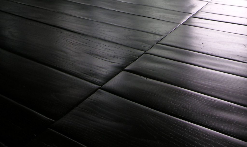 Trapezoidal Planks in black with rectangular shapes.