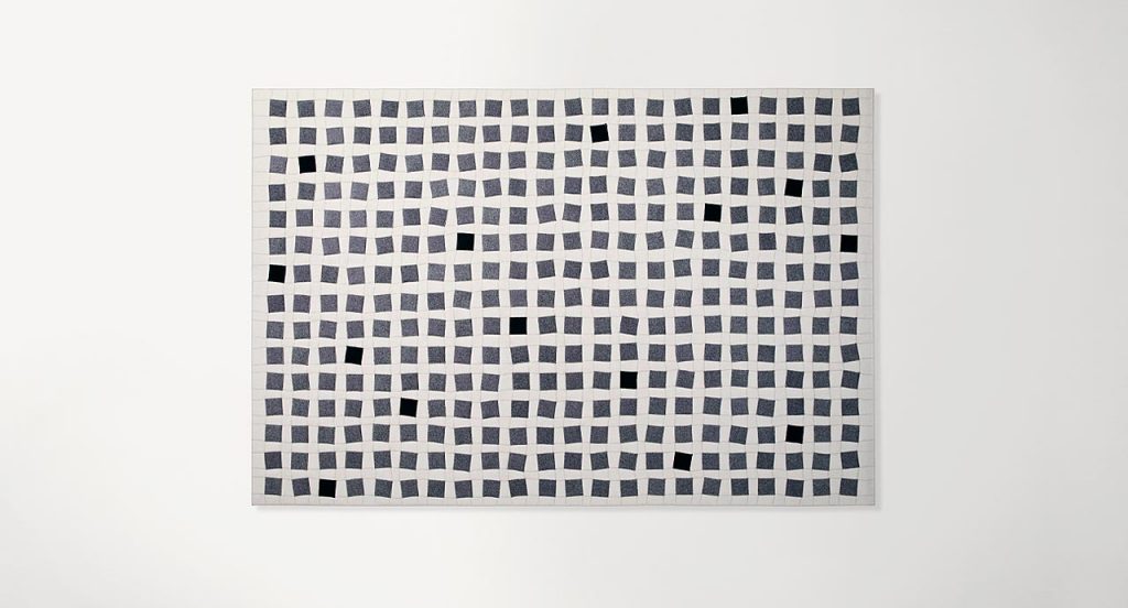 White Continuo rug with grey and black squares like pattern on a white background.