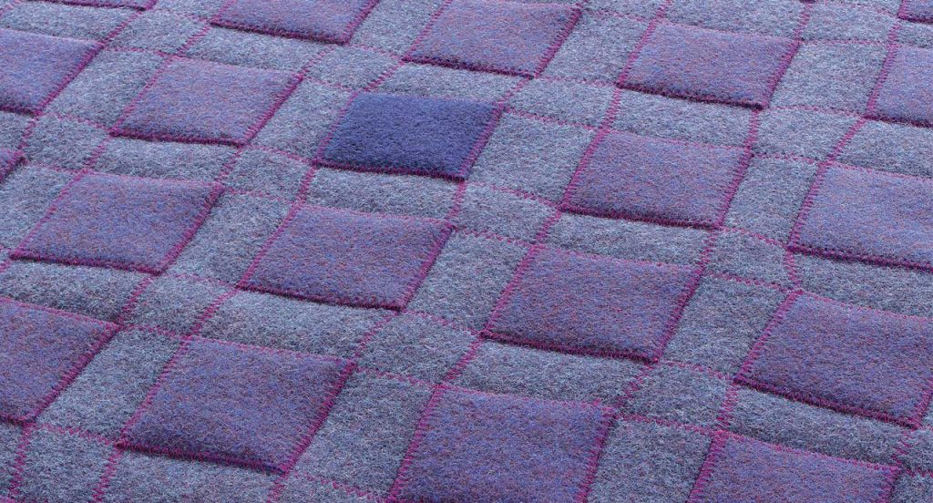 Grey Continuo rug with purple squares like pattern.