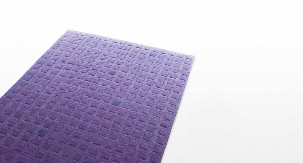 Grey Continuo rug with purple squares like pattern on a white background.