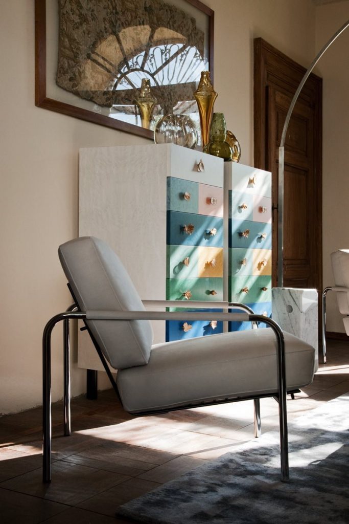 Susanna lounge chair with a sleek metal frame and light gray cushioned seat and backrest.
