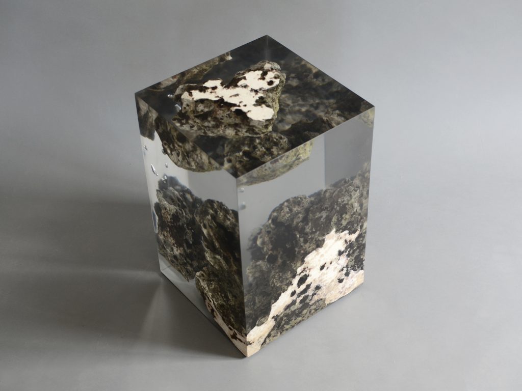 Floating Karst Stool/Side Table with a geometric design, made of natural stone with a transparent resin inlay, set against a gray background.
