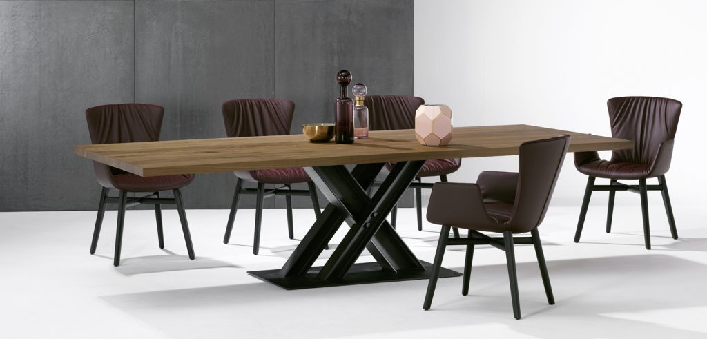 table made of solid light brown wood base and steel base in a black tone with chairs around