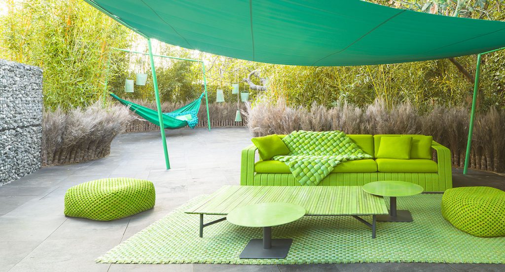 Ala shading structure and four legs made of green steel, shadding sail of green polyester fabric in a terrace.