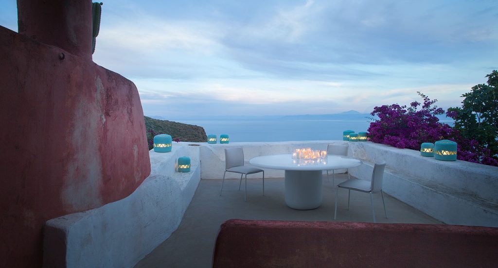 Two white Mae chairs, structure and legs of steel, upholstery in fabric in a terrace.