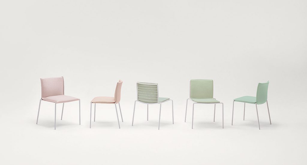 Five Mae chairs, structure and legs of white steel, upholstery of fabric, two in pink and three in green on a white background.