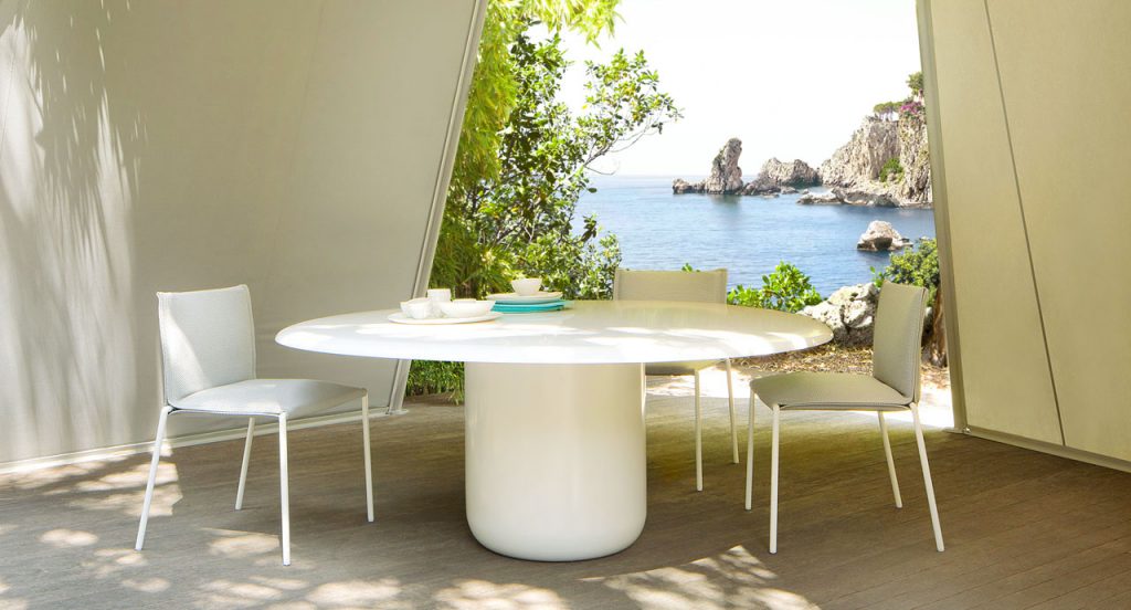 Two white Mae chairs, structure and legs of steel, upholstery in fabric in a terrace.