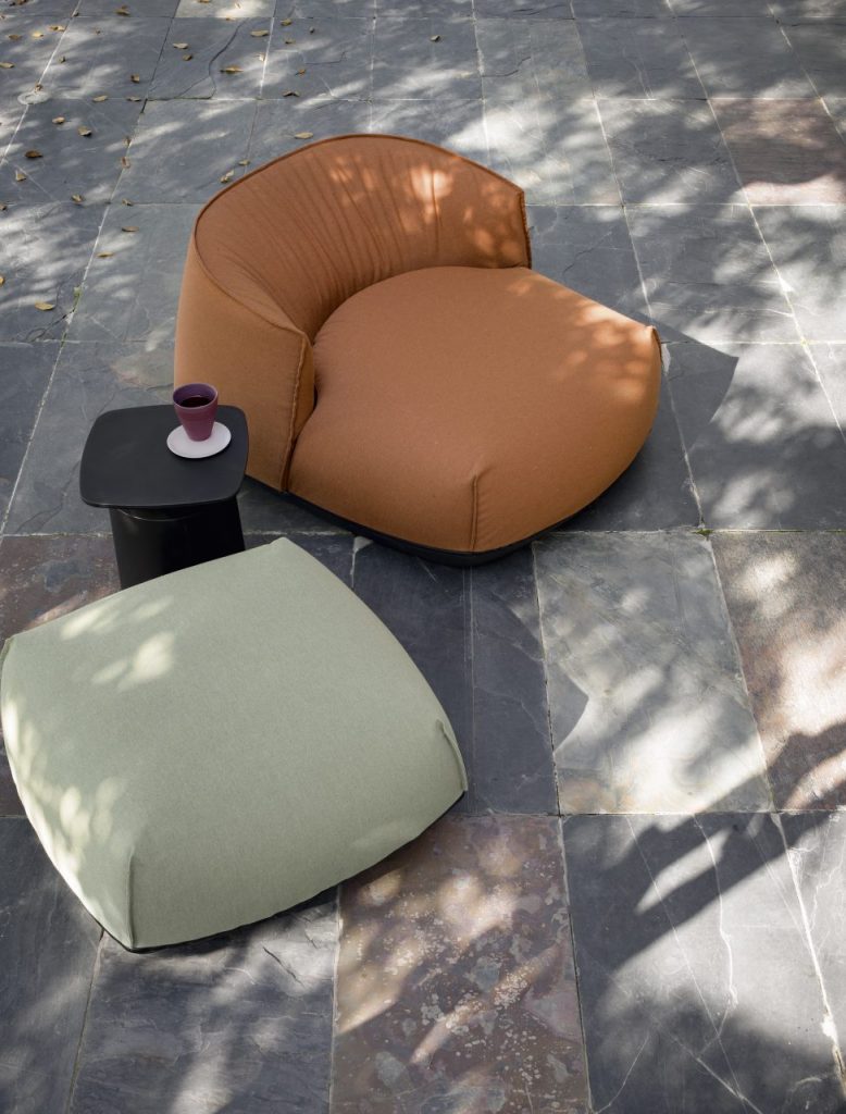 a sofa and a pouf made from Sunbrella® and on a thin base in an orange and light green tone