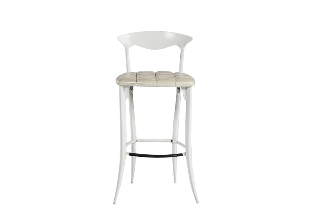 Metal bar stool with white finish. Seat cushion upholstered with beige quilted leather.