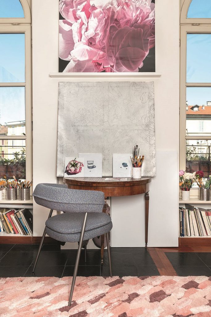 armchair made of a varnished steel base filled with foam upholstered in gray leather in a living room