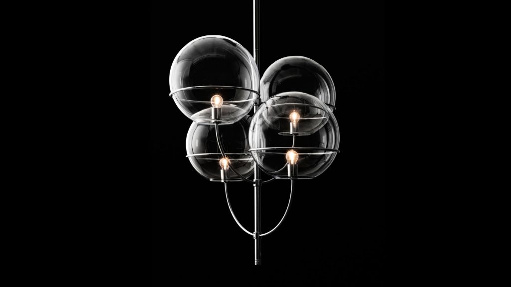 lamp with four transparent glass spheres and black metal base in a black background