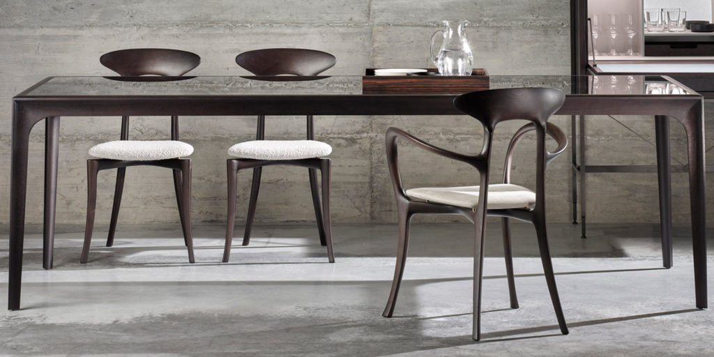 three dining chairs with an opening in the middle made of walnut wood and upholstered in white leather