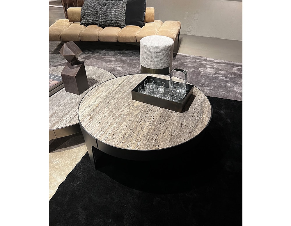 Small circular table made of gray stone and black steel.