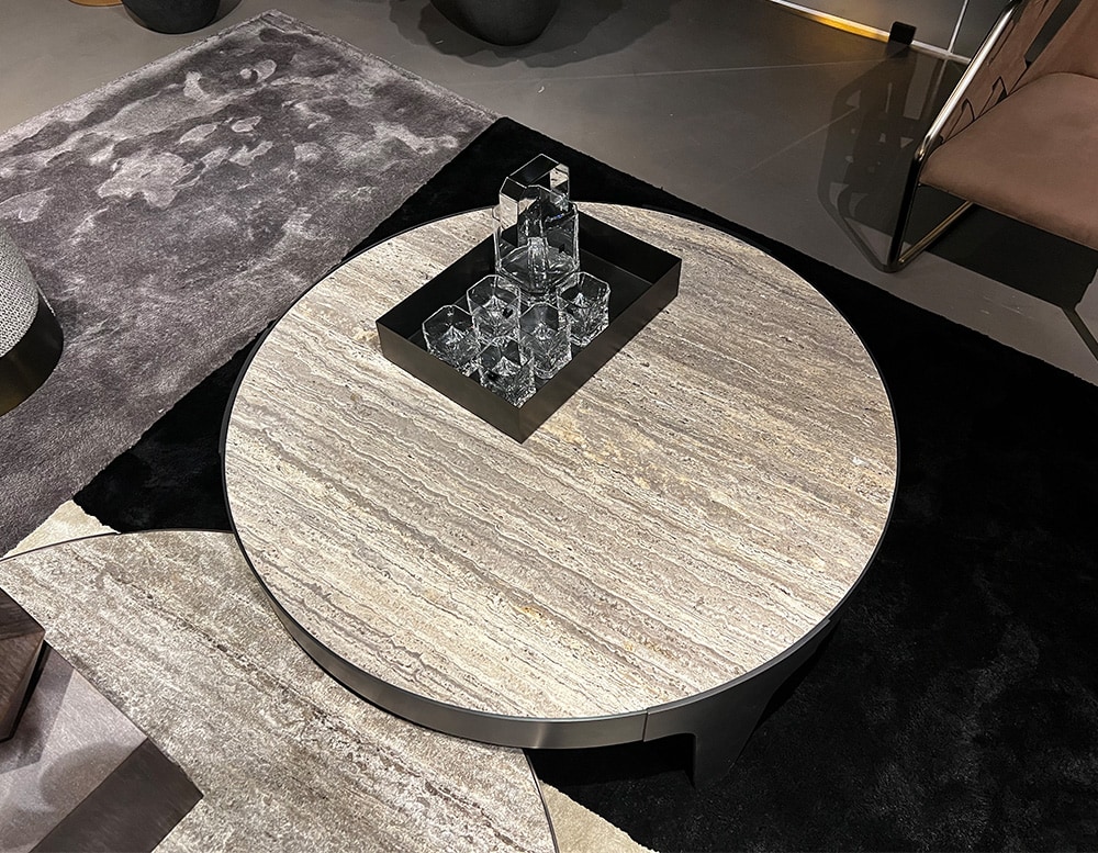 circular centerpiece with black steel base and stone top in a room.