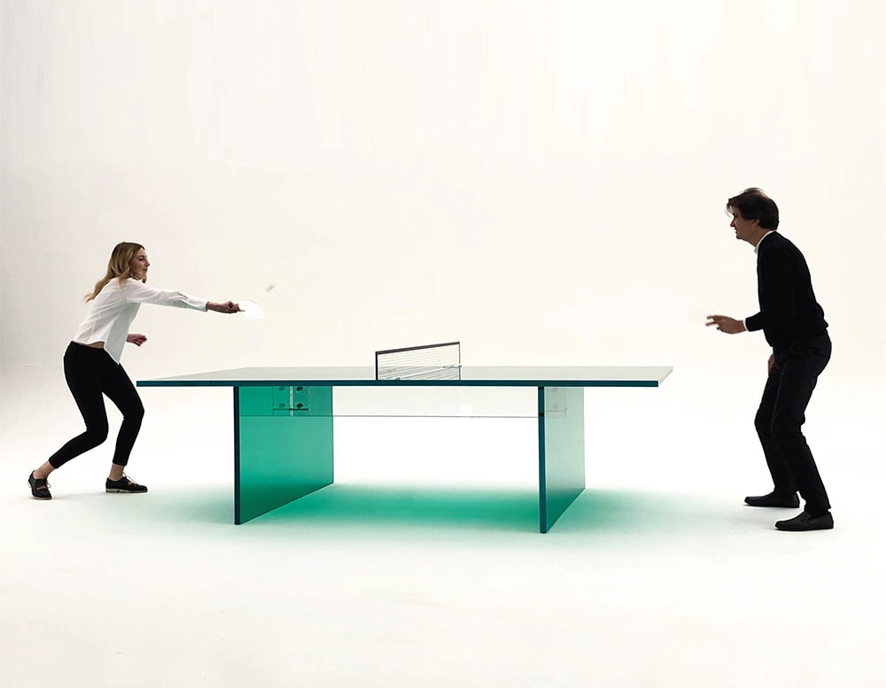 pingpong table made of thick transparent glass with two people in the background