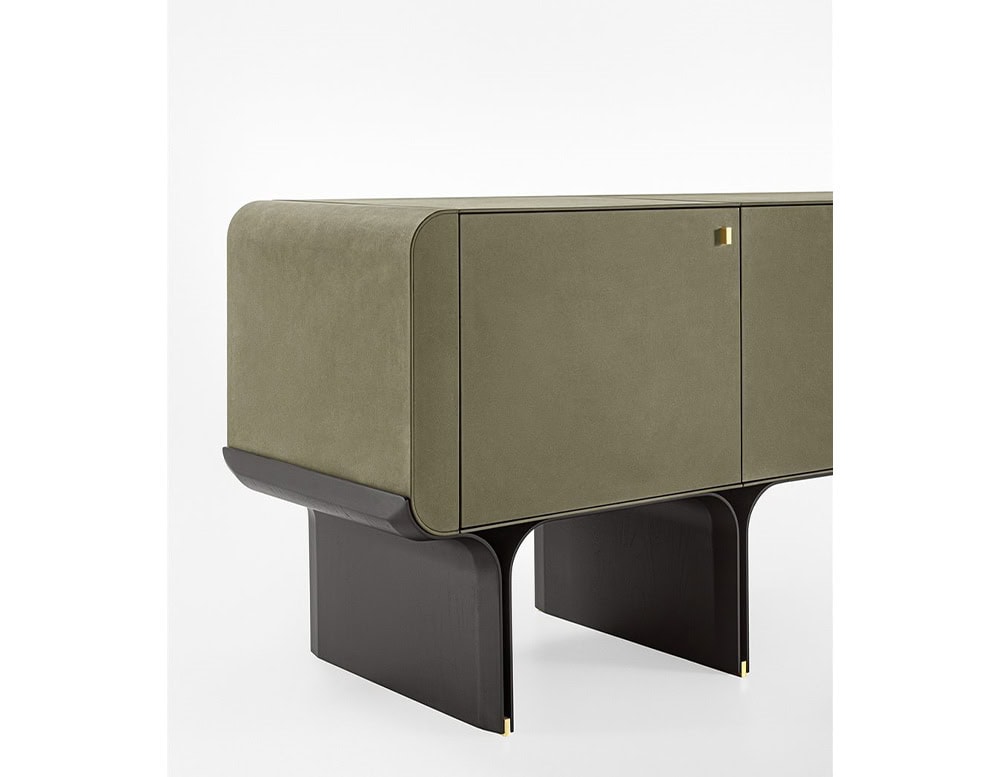 sideboard with curved base made of black ash wood upholstered in leather in a dark green tone on a white background