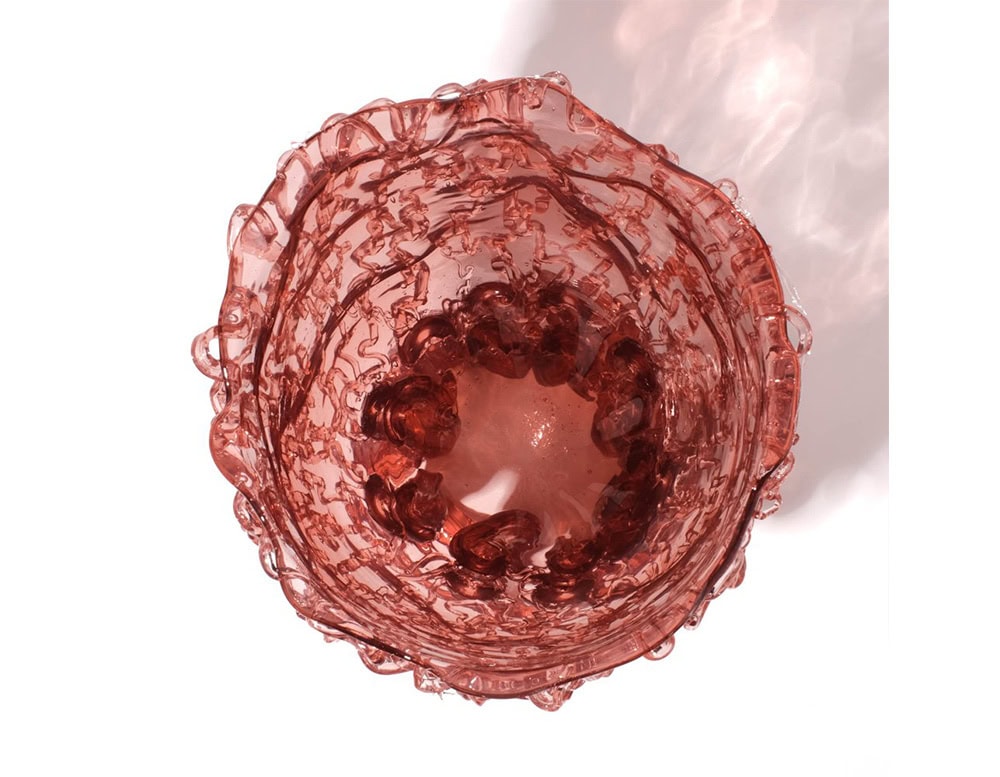 Top view of Medusa Vase Pink in translucent with irregular pattern on a white background.