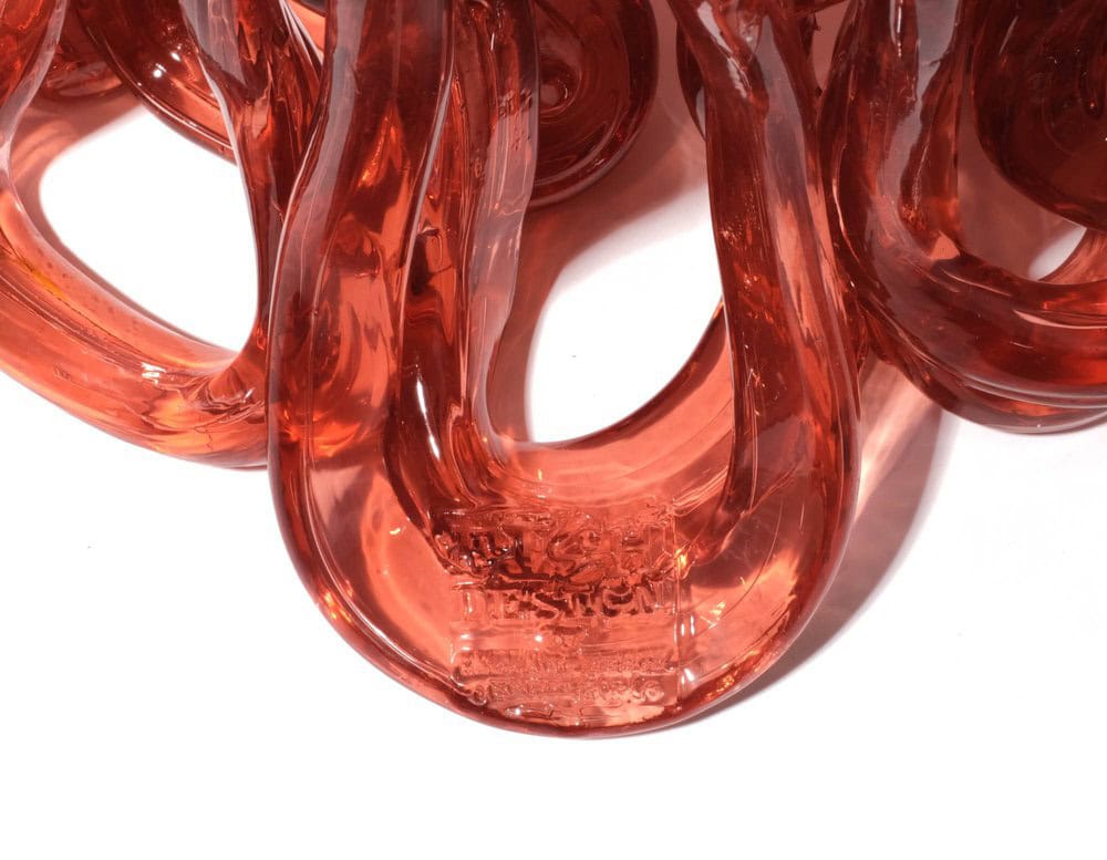 Bottom part of Medusa Vase Pink in translucent with irregular pattern on a white background.