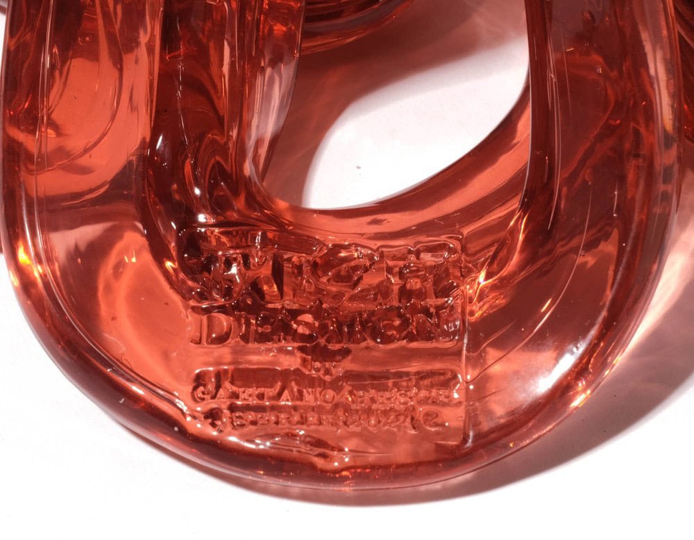 Bottom part of Medusa Vase Pink in translucent with irregular pattern on a white background.