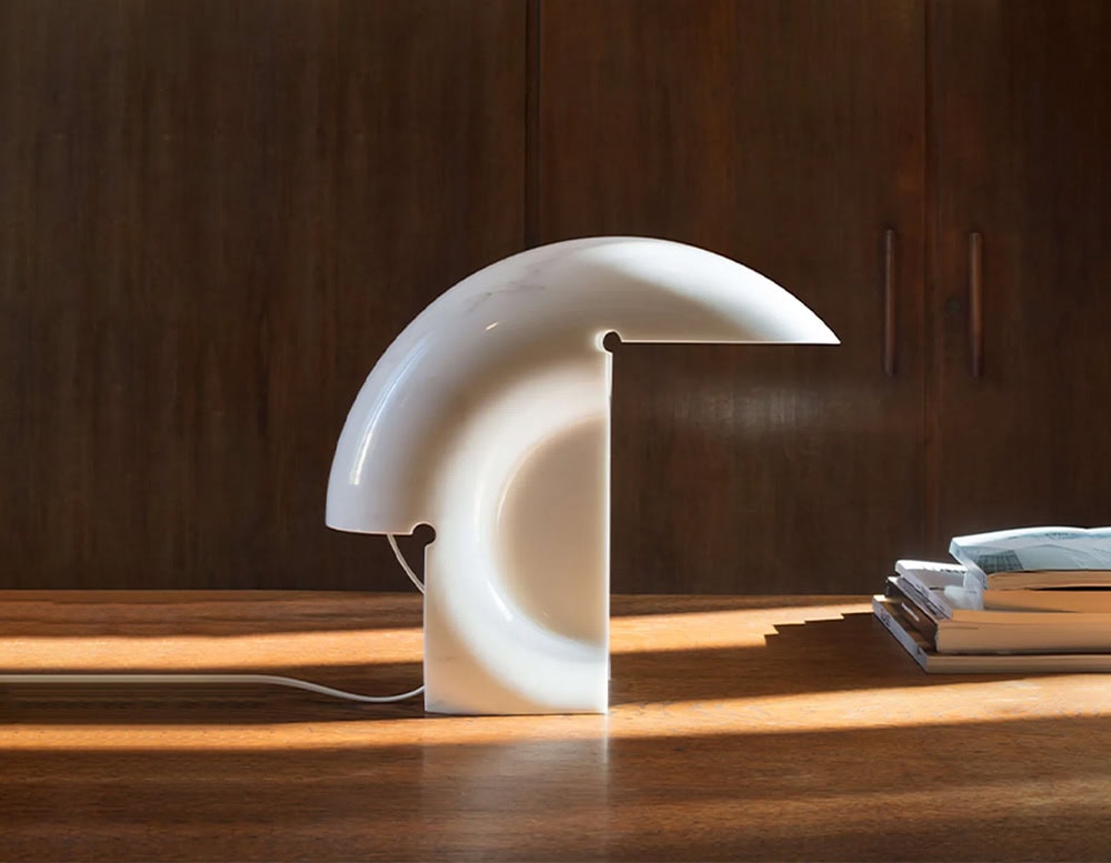 Flos Biagio lamp with irregular shape in silver on a table.