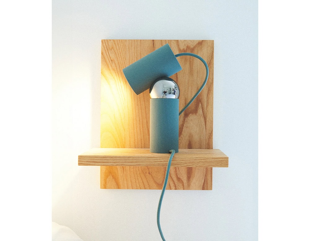 Flos Bilboquet lamp with cylindrical shape in green on a drawer.