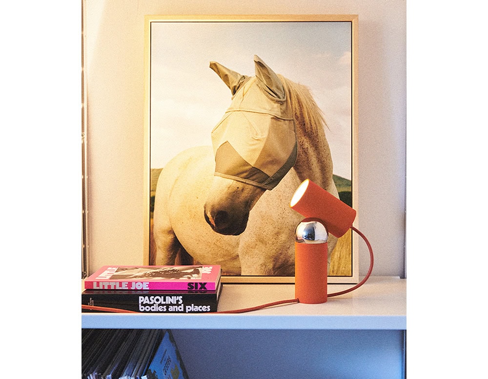 Flos Bilboquet lamp with cylindrical shape in red on a drawer.