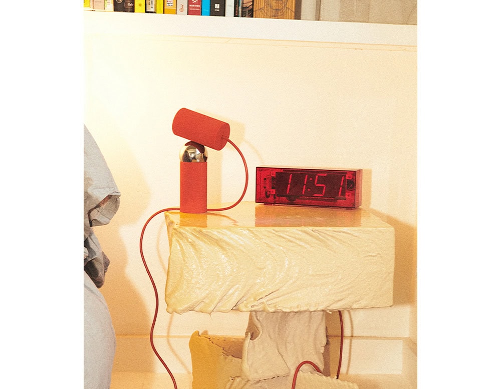 Flos Bilboquet lamp with cylindrical shape in red on a drawer.