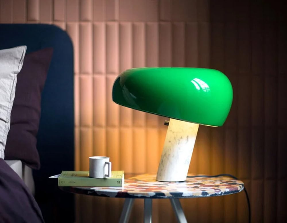 Flos Snoopy table lamp in green atop a marble bedside table